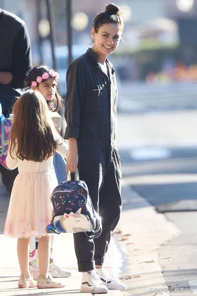 Mila Kunis穿着牛仔连身裤，在洛杉矶放学后背着背包进入妈妈模式